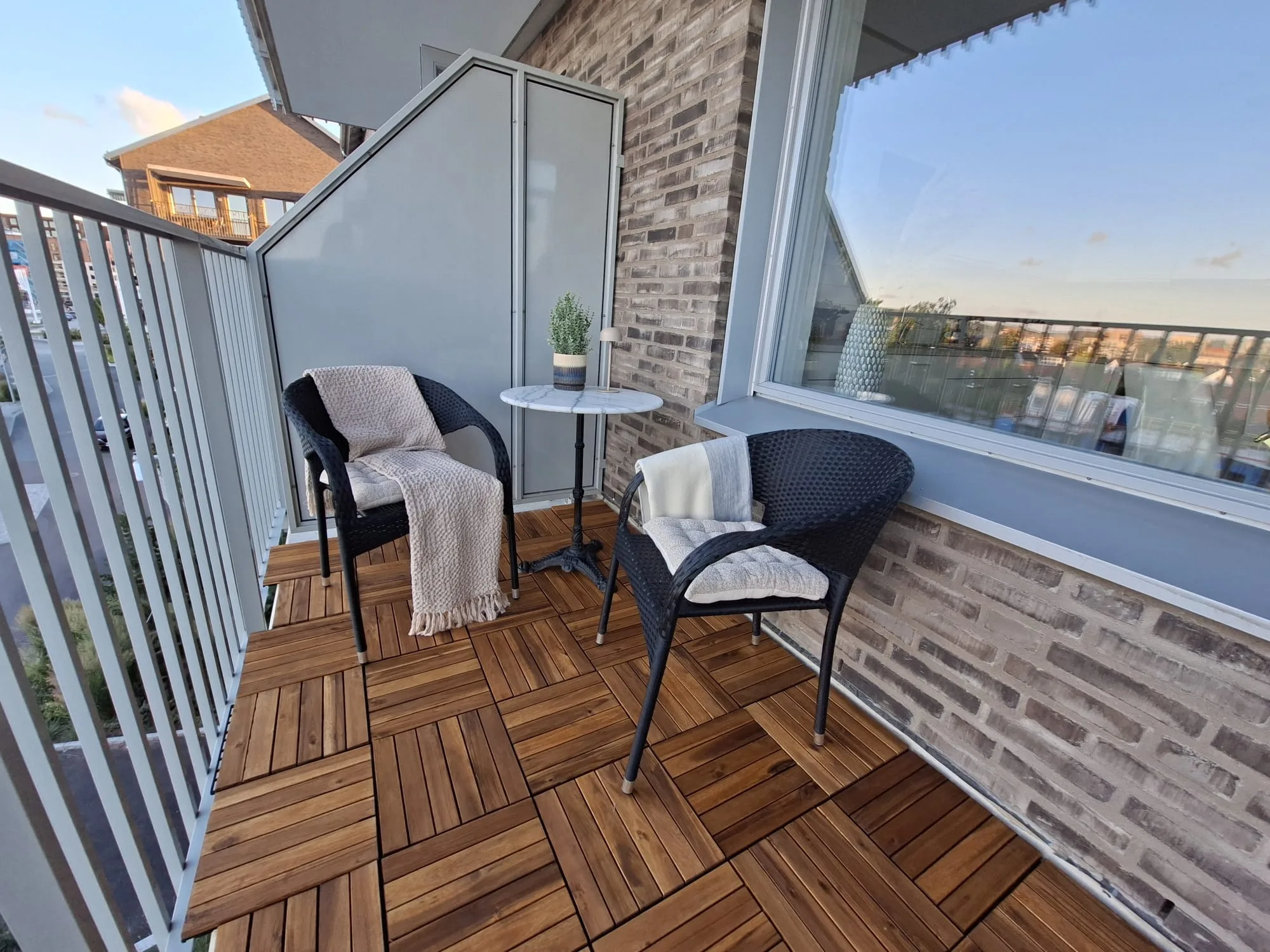 Inredd balkong med sittgrupp i kvällsljus – homestaging i Pedagogen Park, Mölndal | Viva Design