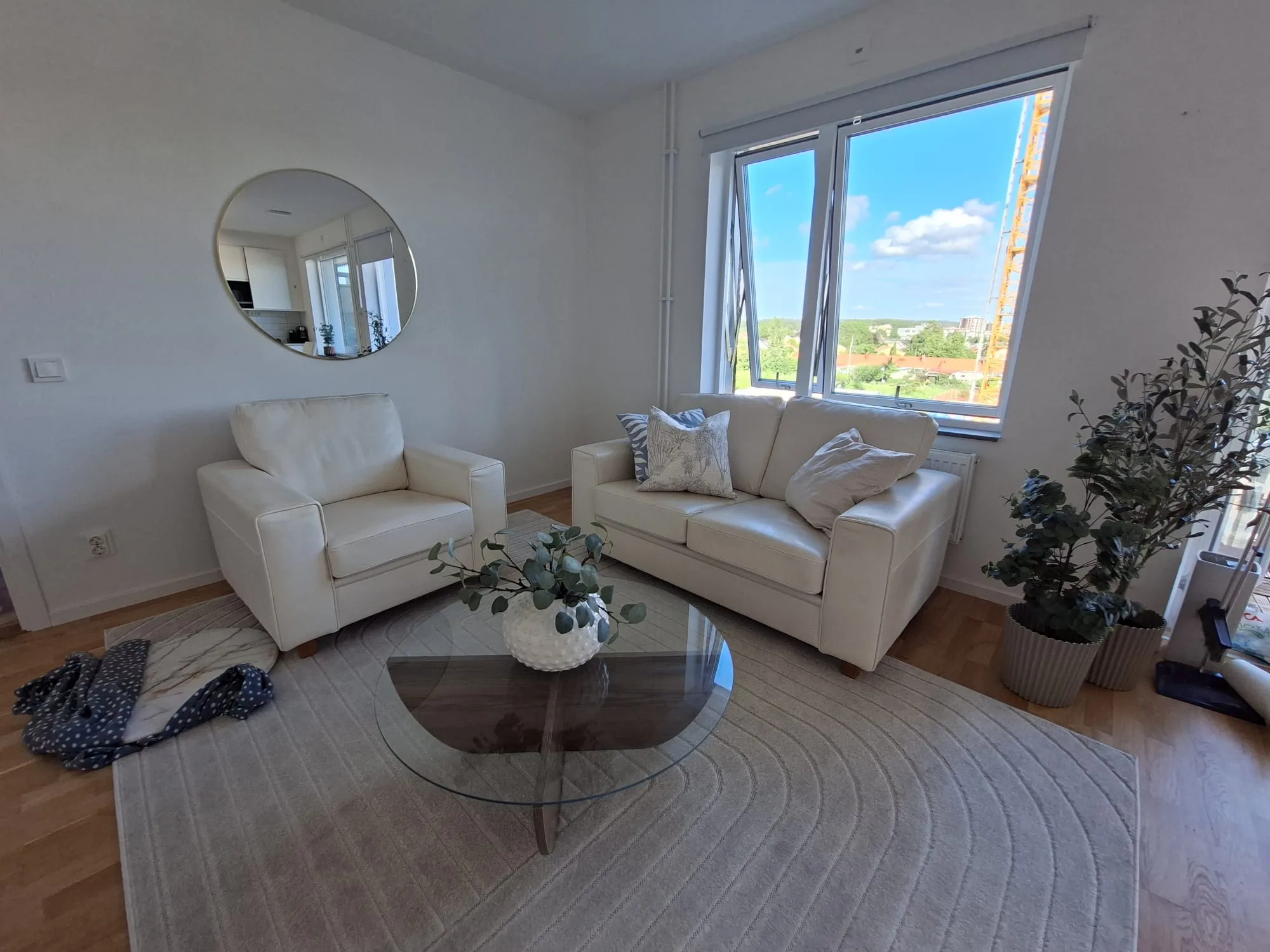 Vardagsrum med vit soffa och rund spegel mot fönstervy – homestaging i Pedagogen Park, Mölndal | Viva Design